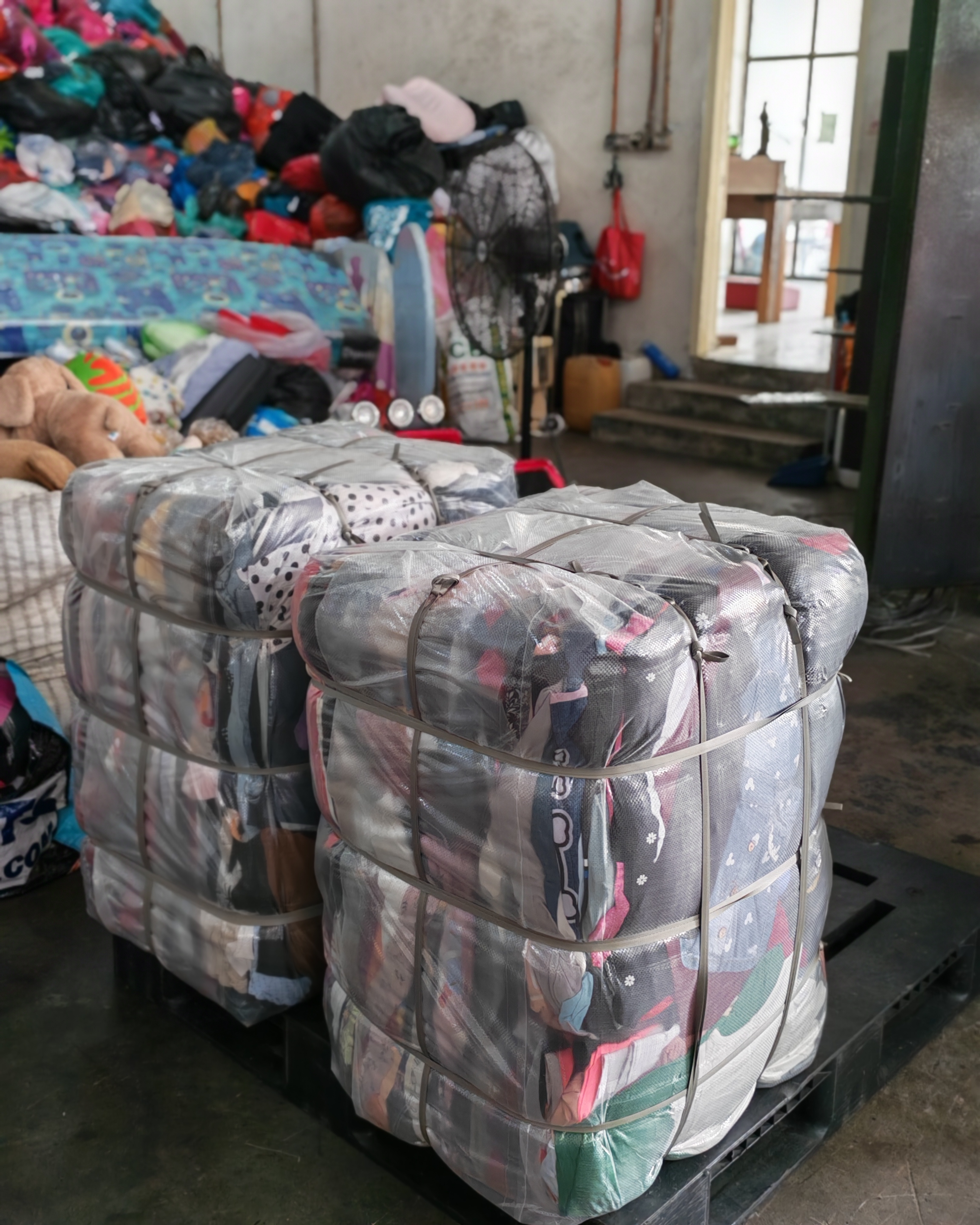 Sorted piles of donated clothing at a collection centre